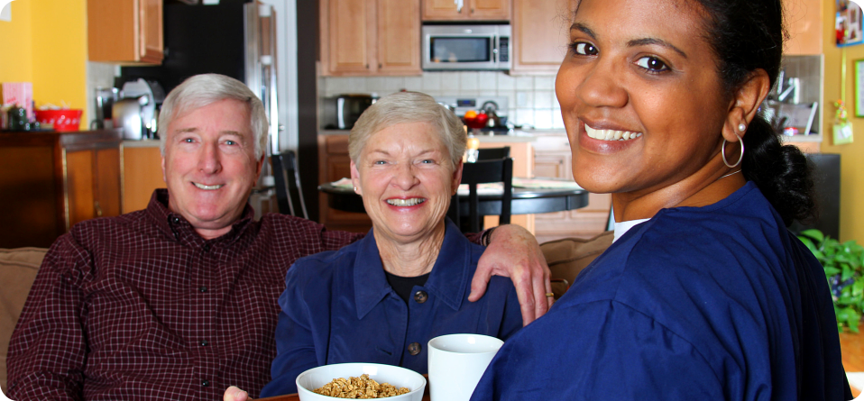 Husband and wife eating with their caregiver